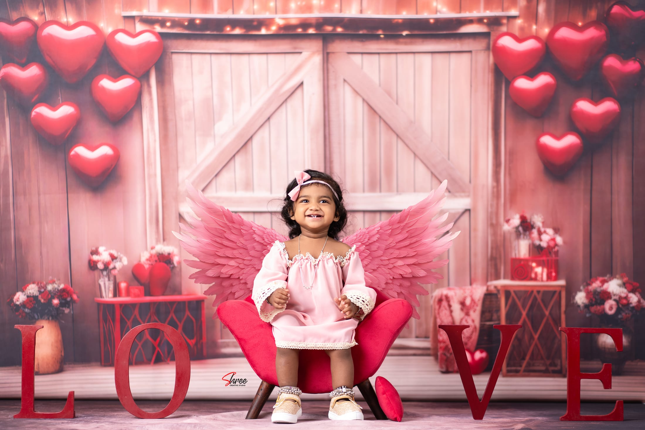 Toddler girl in a pink-winged cupid theme