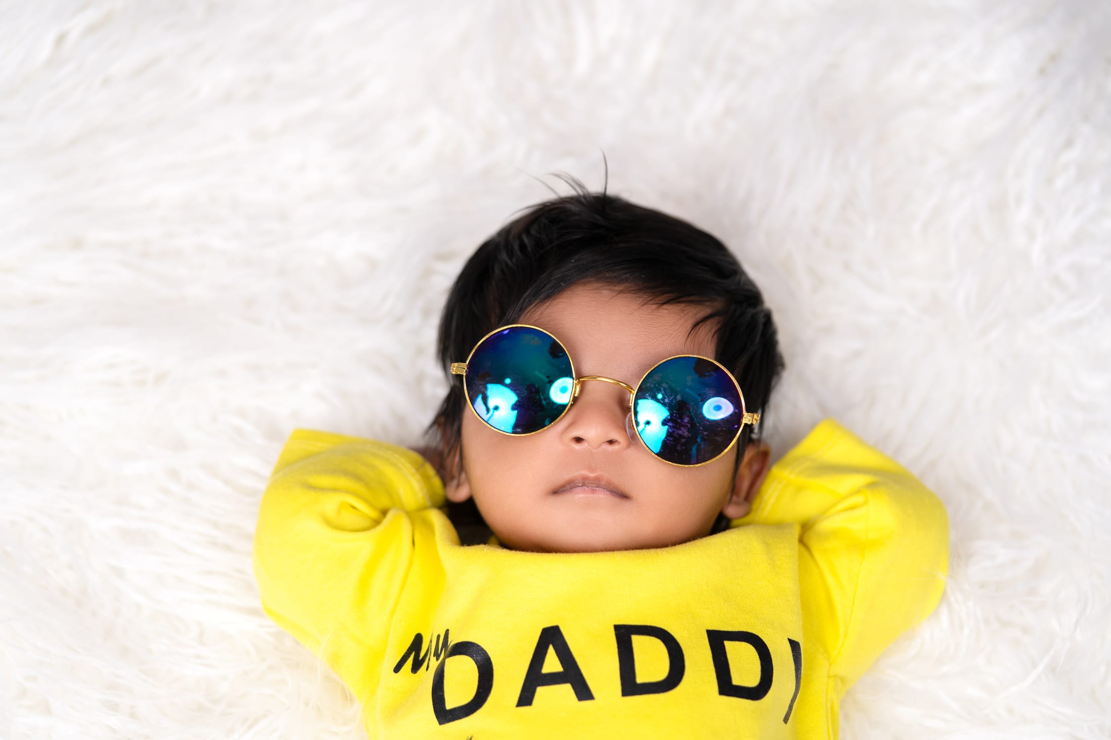 Baby in yellow sunglasses and a playful hoodie