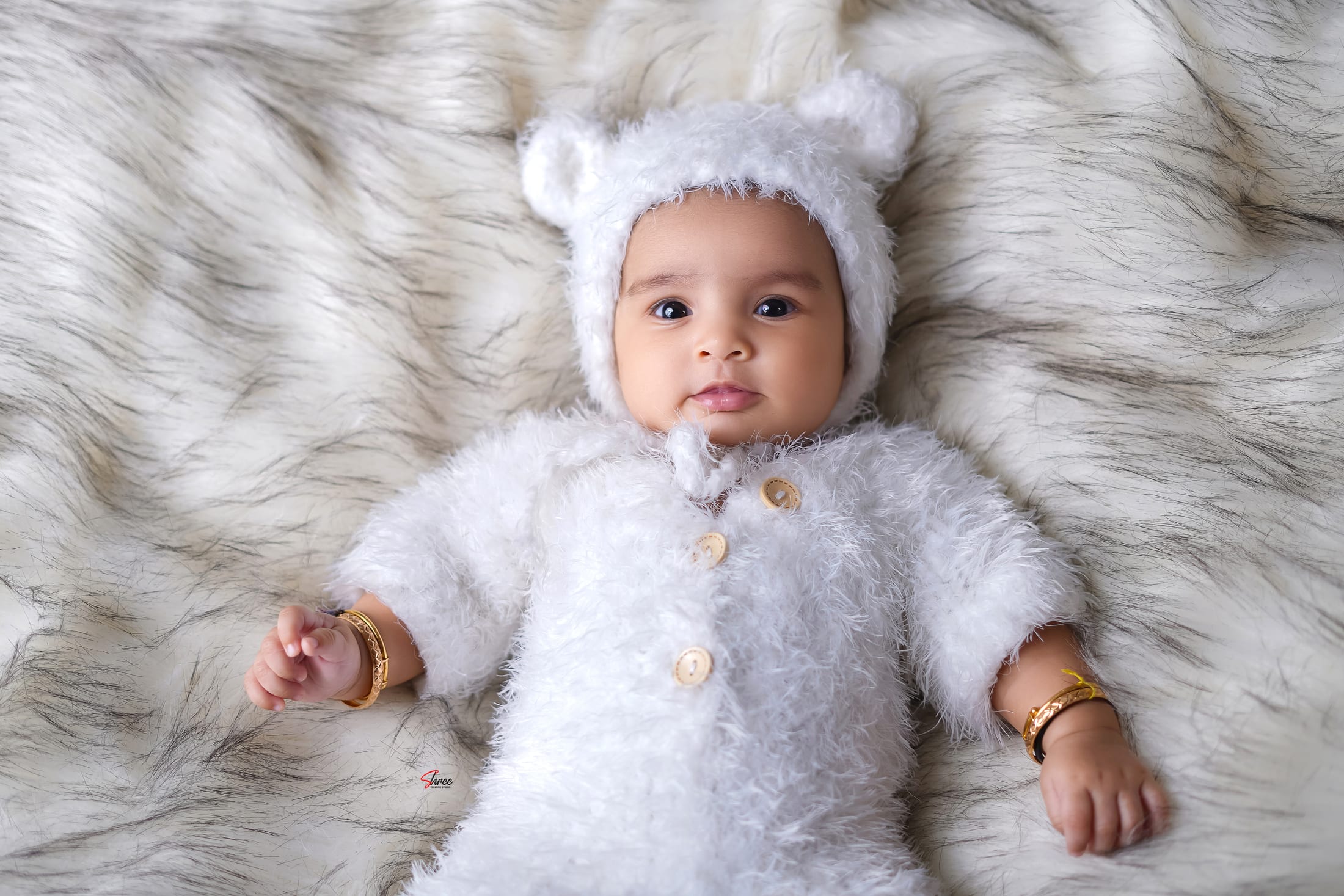 Baby in a cosy bear-hat outfit